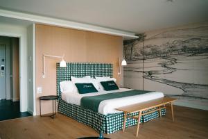 a bedroom with a large bed and a painting on the wall at Empordà Golf Resort in Torroella de Montgrí