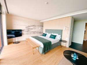 a hotel room with a bed and a flat screen tv at Empordà Golf Resort in Torroella de Montgrí