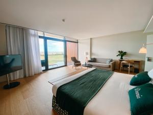 a bedroom with a large bed and a living room at Empordà Golf Resort in Torroella de Montgrí