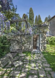 eine Terrasse mit Stühlen und einem Baum mit lila Blumen in der Unterkunft Badia di Pomaio in Arezzo