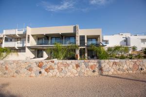 una casa sulla spiaggia con un muro di pietra di DeLight Luxury Rooms a Faliraki