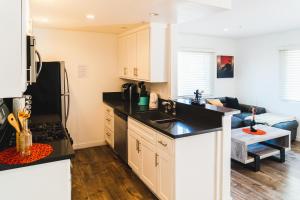 cocina con armarios blancos y encimera negra en One Bedroom Modern Remodeled Close to Koreatown Free Parking en Los Ángeles