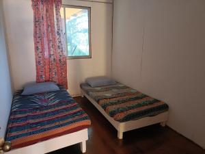 two beds in a small room with a window at Mulu Homestay in Mulu
