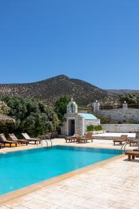 uma piscina com espreguiçadeiras e um resort em Avgerinos Village em Agiassos
