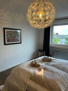 a bedroom with a bed and a large chandelier at Von der Felsen in Prien am Chiemsee