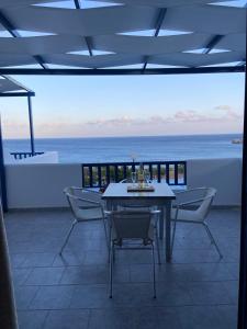 a dining room with a table and chairs and the ocean at Ardani Bay Studios in Amoopi