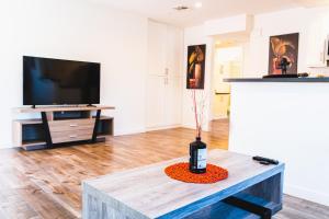 a living room with a tv and a table with a vase at One Bedroom Modern Remodeled Close to Koreatown Free Parking in Los Angeles