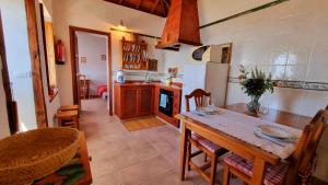 a kitchen with a wooden table and a kitchen with a stove at Rincón de Mercedes in Fuencaliente de la Palma