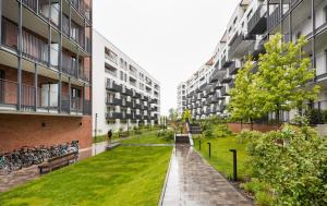 a courtyard in an apartment building with grass and bicycles at Bohema Place - Metro Szwedzka Apartment in Warsaw