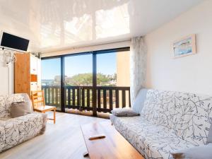 salon z kanapą i balkonem w obiekcie Appartement lumineux à Gruissan, 2 chambres, proche plage, parking sécurisé, mini-box WIFI, non-fumeur - FR-1-409A-15 w mieście Gruissan