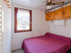 um quarto com uma cama roxa e uma janela em Appartement Gruissan, 3 pièces, 6 personnes - FR-1-409A-15 em Gruissan