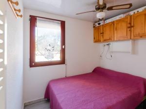 sypialnia z fioletowym łóżkiem i oknem w obiekcie Appartement lumineux à Gruissan, 2 chambres, proche plage, parking sécurisé, mini-box WIFI, non-fumeur - FR-1-409A-15 w mieście Gruissan