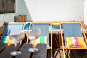 una mesa con sillas y copas de vino. en Ambassador Private Pool Suites en Lisboa