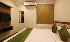 Treebo Trend Address Inn في حيدر أباد: غرفه فندقيه سرير وتلفزيون