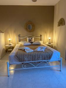 a bed in a bedroom with two lamps on tables at Ardani Bay Studios in Amoopi