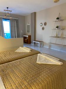 sypialnia z 2 łóżkami, stołem i oknem w obiekcie Ardani Bay Studios w mieście Amoopi