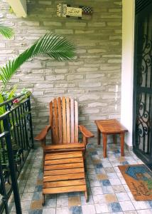 una silla de madera y un banco en un porche en Home Bliss Hotel- Fort portal Uganda en Fort Portal