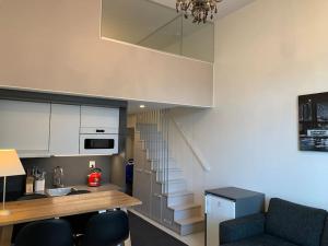 a kitchen with a staircase and a table and chairs at Viihtyisä koti in Vantaa