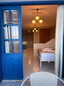 Una puerta azul que conduce a un dormitorio con cama en Ardani Bay Studios en Amoopi