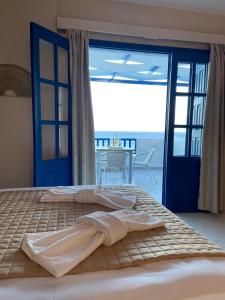 a bedroom with a bed with a view of the ocean at Ardani Bay Studios in Amoopi