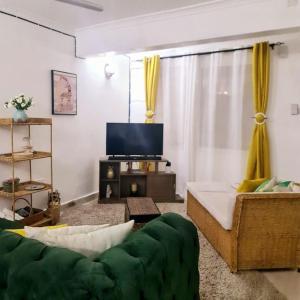 sala de estar con sofá y TV de pantalla plana en Stylish 2 Bedroom House in Mtwapa, en Mtwapa