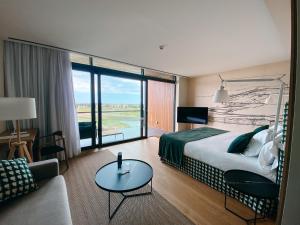 a hotel room with a large bed and a couch at Empordà Golf Resort in Torroella de Montgrí