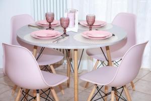 uma mesa branca com placas cor-de-rosa e óculos em Olive House em Kalamata
