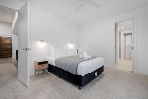 a white bedroom with a bed and a night stand at Marvellous Montfort in Blairgowrie +30 photos