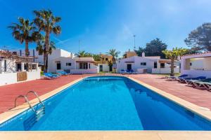 a swimming pool in a villa with palm trees at Son Xoriguer 14 in Son Xoriguer