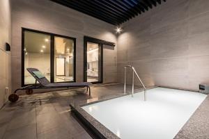 a swimming pool with a chair in a room at Via Inn Prime Osaka Kyobashi in Osaka