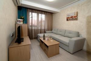 a living room with a couch and a television at COOP Apartments, Sofia in Sofia