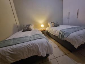 two beds sitting next to each other in a room at Hoep Hoep Self Catering in Groblersdal