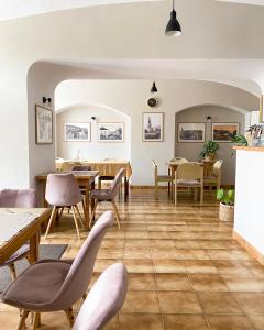 un ristorante con pavimenti e tavoli in legno e sedie di Bed & breakfast Hugo a Plešivec
