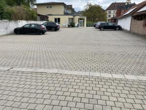 ein Parkplatz mit mehreren Autos, die darin geparkt sind in der Unterkunft BELLEVUE-Boardinghouse in Lichtenfels