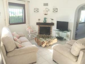a living room with two couches and a tv at Villa Alejandria in Moraira