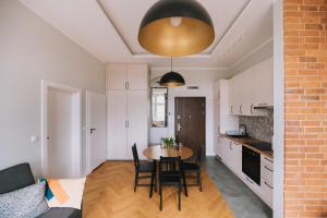a kitchen and dining room with a table and chairs at Apartament Słoneczny in Toruń