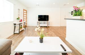 a living room with a white table and a tv at Koreatown 1 Bedroom Close to Downtown LA in Los Angeles