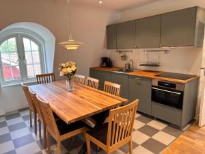 a kitchen with a wooden table and some chairs at Oxgården in Vimmerby