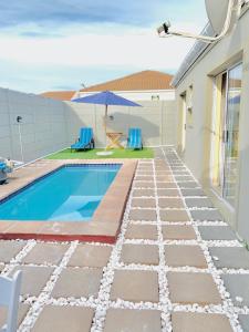 Casa con piscina y sombrilla en Naliya Guest house en Ciudad del Cabo