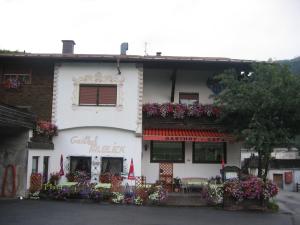 Biały budynek z kwiatami na boku w obiekcie Appartement Paulis Hof w mieście Ischgl