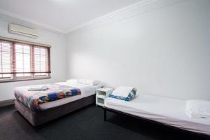 Łóżko lub łóżka w pokoju w obiekcie The Emperors Crown Hostel
