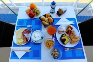 una mesa con platos de comida y fruta. en Hotel Sporting Club, en Altavilla Milicia