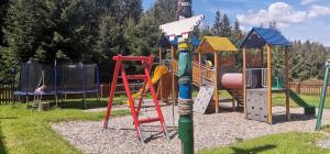 un parque infantil con diferentes tipos de equipamiento de juegos en Drevenica Zuberec, en Zuberec
