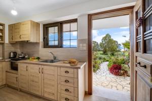 a kitchen with a sink and a door to a yard at Lefkada view villa Vasiliki 2 in Peratiá