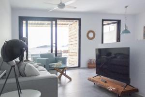 ein Wohnzimmer mit einem Sofa und einem Flachbild-TV in der Unterkunft Terrazas Faro 18 in El Pozo de los Frailes