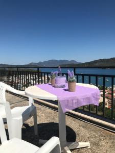 a table with a purple table cloth on a balcony at Beautiful view of poros in Galatas