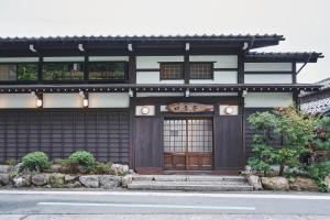 een zwart-wit gebouw met een houten deur bij 奥琵琶湖　四季亭 in Kaizu