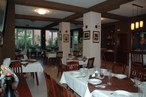 Un restaurante con mesas y sillas con manteles blancos. en Apartmani Goran i Jelena Zec, en Budva