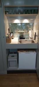 uma pequena cozinha com um lavatório e um lavatório em B en B Op Steendam, Het Voorhuis em Steendam