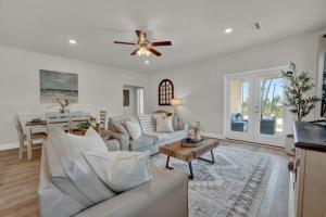 Il comprend un salon doté d'un mobilier blanc et d'un ventilateur de plafond. dans l'établissement Sea la Vie, à Saint Joe Beach